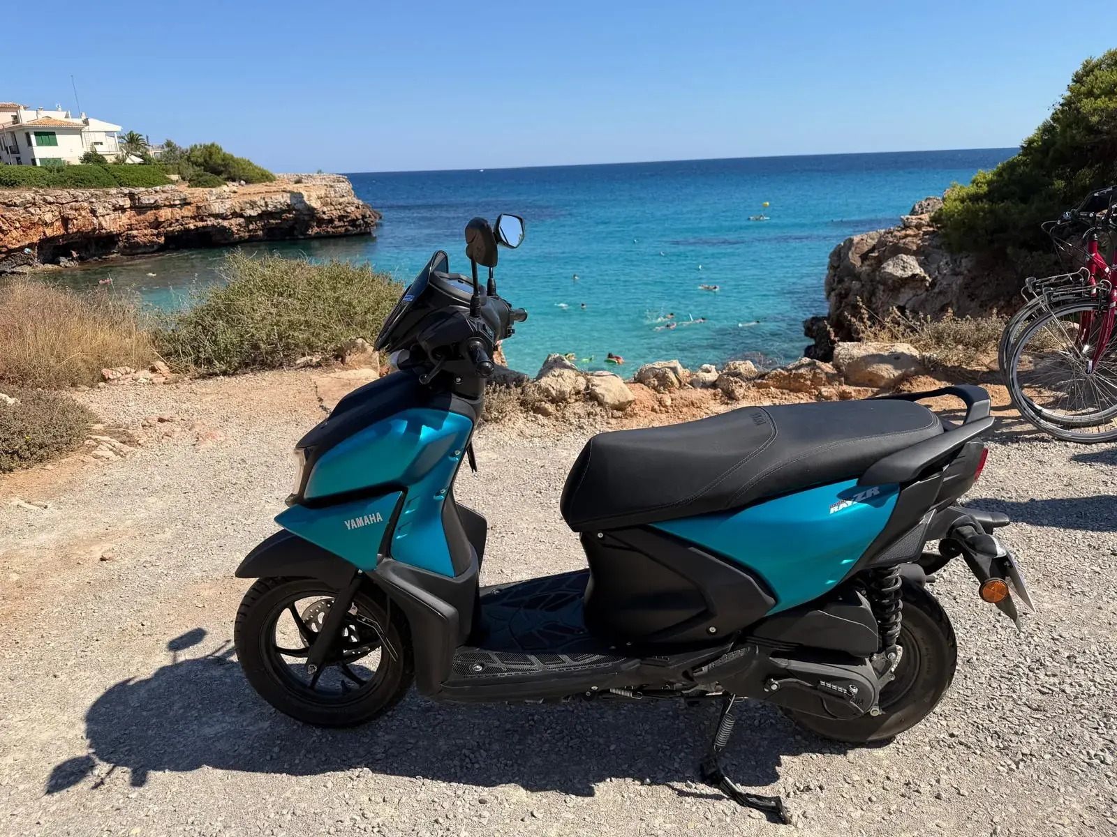 Yamaha RayZR 125 in türkis an einer Bucht bei Cala Millor